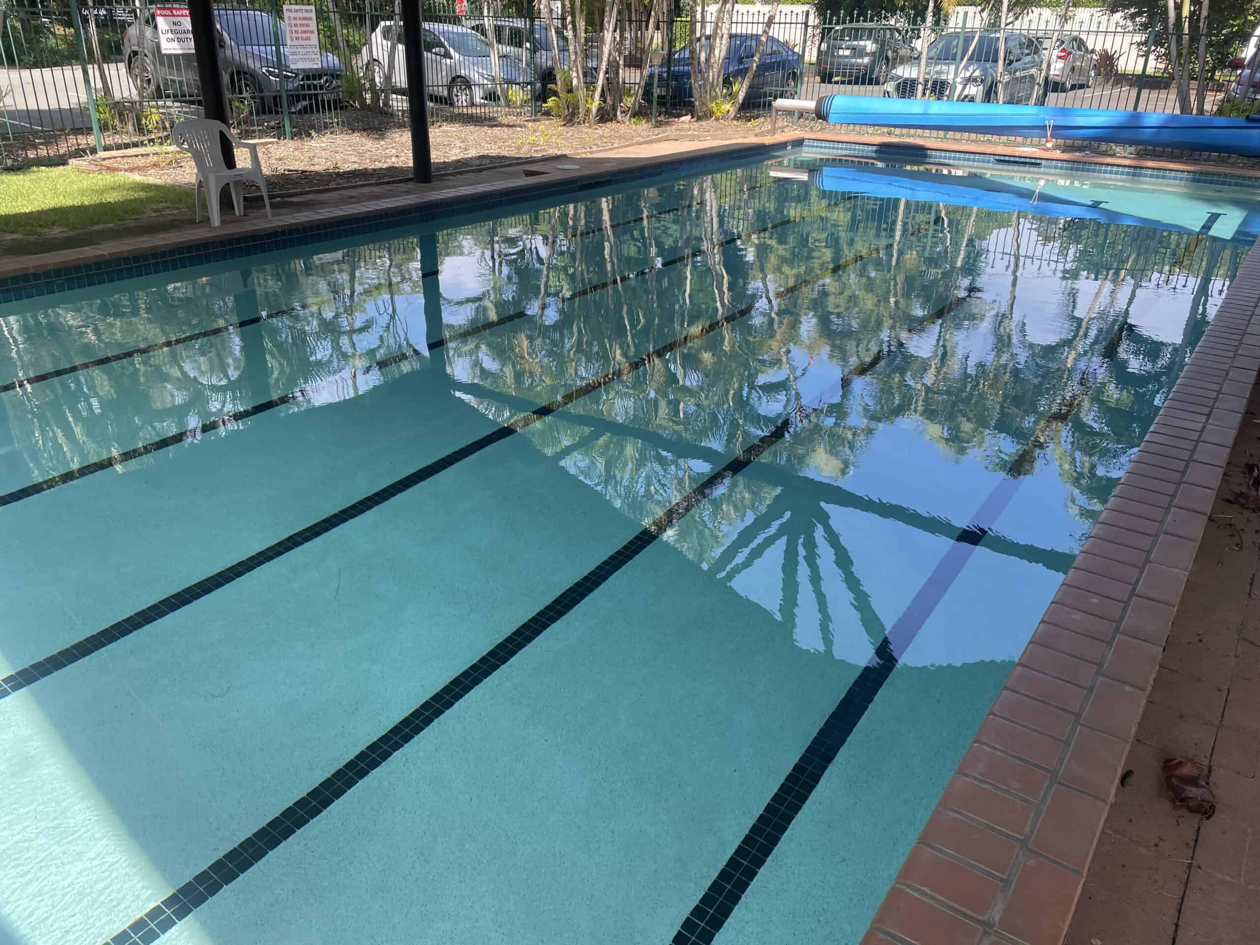 Pool with lanes with a pool cover rolled up at one end