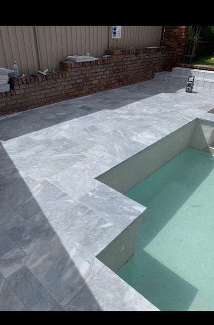 An empty pool with grey tiles