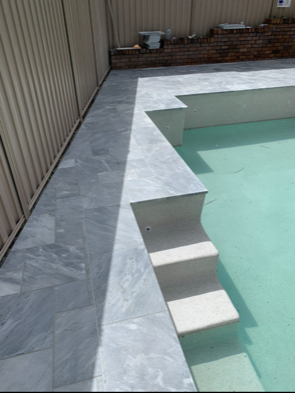 renovated pool with white steps and light grey tiles