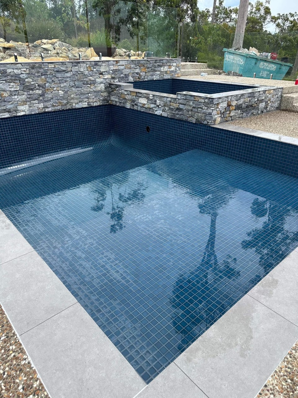 empty pool with shiny dark blue tiles